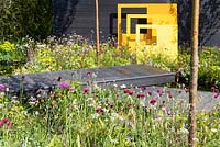 Yellow steel sculptural panels with black decking and meadow-style planting. 'Urban Oasis', RHS Malvern Spring Festival 2018.