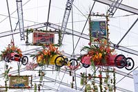 Displays in hanging retro cars. Great Pavilion of Art and Flowers - RHS Malvern Spring Festival, 2018.