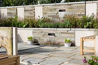 Water spouts and rill in stone clad wall  with low planting of Tiarella 'Iron Beauty - The Yardley Flower Garden, Ascot Spring Garden Show, 2018 