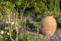 Terracotta water pot with multi-stem Malus toringo - crab apple tree and Rosa 'Gentle Hermione'. 'Best of Both Worlds', RHS Hampton Flower Show 2018