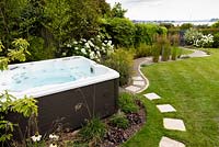 View of garden jacuzzi surrounding by planting.