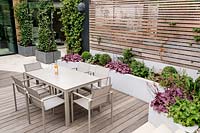 Curved wooden decking and stone patio with garden furniture Contemporary garden in Dulwich 