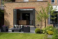 Lounge furniture on patio with view to house extension with bifold doors