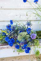 Loose bunch of summer flowers, including cornflowers, ammi visnaga and sea holly.