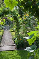 View through hazel arch into the Tunnel Garden. Heale House, Middle Woodford, Salisbury, Wilts, UK. 