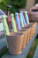 Row of biodegradable pots with clothes peg labels