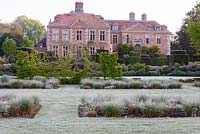 Tussocks of new grass in beds framed by frosty grass at Heale House, Middle Woodford, Wiltshire 