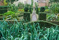 Walled kitchen garden with box edged beds and central sun dial. 