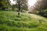 Grass maze on sloping ground in a country garden. 
