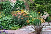 View of flowering herbaceous border around courtyard. 
