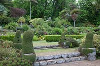 View up the garden with beds of drought-tolerant plants and unusual topiary
 