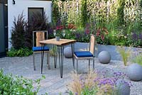 Gravel and stone recycled timber patio chairs. Secured by Design Garden, RHS Hampton Court