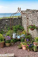 Tall dry stone wall wards off sea breezes from a small courtyard.