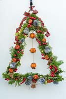 Decorated steel frame with yew, conifer and rosemary foliage with clementine clove pomanders