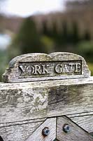 Engraved wooden gate at York Gate garden, Leeds, UK.