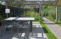 Garden patio and dining area surrounded by wooden pergola with wicker screens.