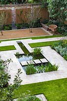 Overview of formal pond and stepping stones in walled city garden. Garden design by Peter Reader Landscapes.