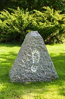 Stone with footprint at the entrance. Plaz Metaxu Garden, Devon, UK.