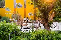 Seating area in drought tolerant garden. Santa Rita 'Living La Vida 120' Garden, Sponsored by Santa Rita Wines, RHS Hampton Court Flower Show, 2018.
