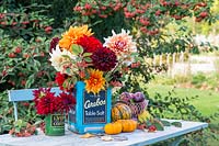 Cut Dahlias in vintage tin cans with fruit and vegetables.