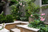 Secluded courtyard with trellis fencing, steps  and brick walls