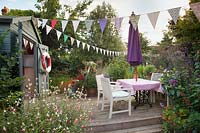 Coastal style garden, with beach inspired summerhouse, bunting and raised decking area. 