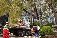 Parts of pavilion unloaded from lorry by crane in preparation for RHS Chelsea Flower Show