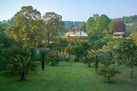 View across lawns and the kitchen garden to large country house, Bickham House, Devon,UK.  