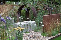 Detail of monolothic steel structures and wildflowers in Brownfield - Metamorphosis garden at Hampton Court Flower Show, London, 2017. 