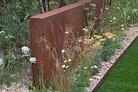 Detail of monolothic steel structures and wildflowers in Brownfield - Metamorphosis garden at Hampton Court Flower Show, London, 2017.