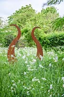 Rusty steel Lyre sculpture in a wild garden. 