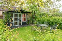 Garden summerhouse with metal table and chairs.