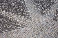 Close-up of decorative star-shaped in paving made with cobblestones 