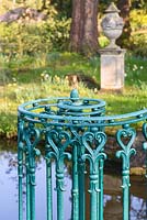 Brige with ornate blue, metal railing - Swiss Garden, Old Warden near Biggleswade, UK. 