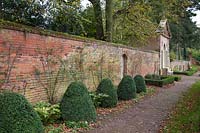 Walled garden with clipped Buxus pyramids and summer house at Castle Bromwich Hall Gardens, UK. 