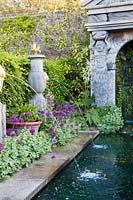 Italianate water fountains in The Collector Earl's Garden with alliums, aquilegia, iris and Alchemilla mollis. Arundel Castle, Sussex, UK
