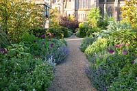 Gravel pathway bordered by mixed perennial flowerbeds. Arundel Castle, West Sussex, UK. 