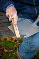 Sharpening a spade using a tool sharpener and oil