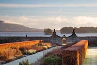 Last moments of saturated winter sun on the beech hedges and double herbaceous borders flanking the central path, Loch Leven beyond