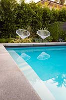A pair of vintage Acapulco garden chairs by the swimming pool in Californian Garden. Designed by Falling Waters Landscape, inc Ryan Prange, New Port Beach, California, USA.