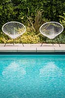 A pair of vintage Acapulco garden chairs by the swimming pool in Californian Garden. Designed by Falling Waters Landscape, inc Ryan Prange, New Port Beach, California, USA.
