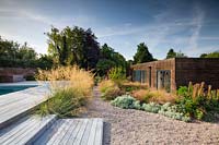 Mixed border of perennials and grasses by house, in contemporary country garden near Winchester, Hants, UK. Designed Elks-Smith Garden Design.