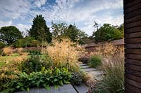 Stipa gigantea 'Gold Fontaene' in contemporary country garden near Winchester, Hants, UK. Designed Elks-Smith Garden Design.