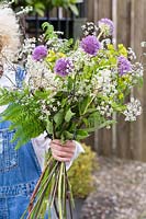 Woman arranging bouquet of spring flowers.