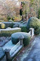 Looking down on topiary clipped into assorted shapes, near railings