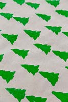 Brown wrapping paper stamped with continuous christmas tree pattern.