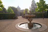 Formal fountain in Collector Earl's Garden, with the Fitzalan Chapel beyond. Arundel Castle, Sussex, UK.

