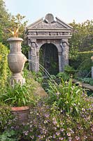 Italianate fountains in Collector Earl's garden, alongside pool with flowering Agapanthus, Lobelia and Scaevola. Arundel Castle, Sussex, UK.