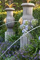 Italianate fountains in Collector Earl's garden, with flowering Agapanthus, Lobelia and Scaevola. Arundel Castle, Sussex, UK.