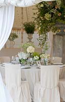 View of wedding table decorations in white and green. 